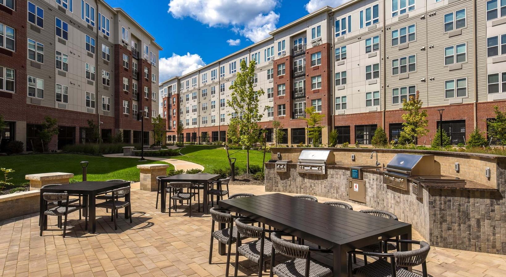 State-of-the-art amenities a courtyard with grills, tables and chairs