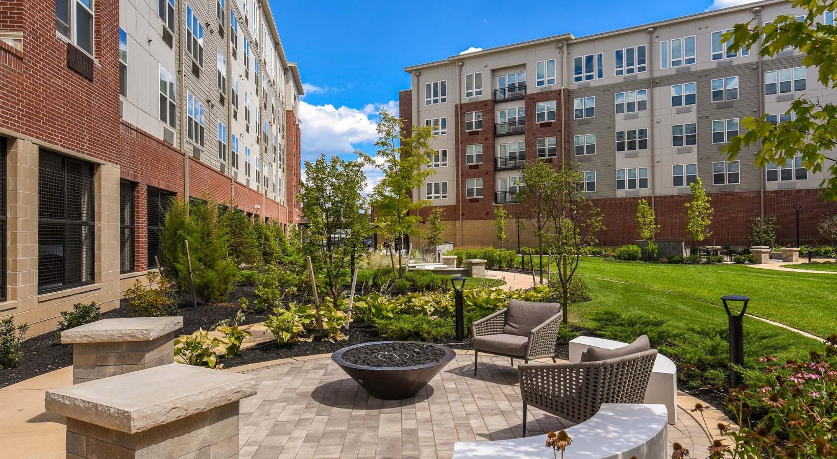 Quick access to state-of-the-art amenities a courtyard with tables and chairs and a building in the background
