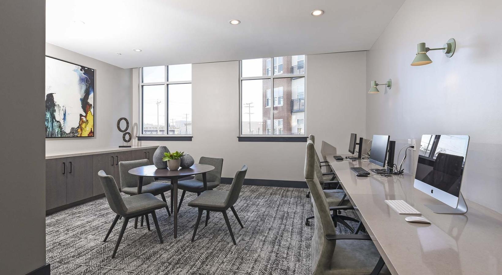 Cutting-edge amenities at your fingertips a community computer room with a desk and chairs