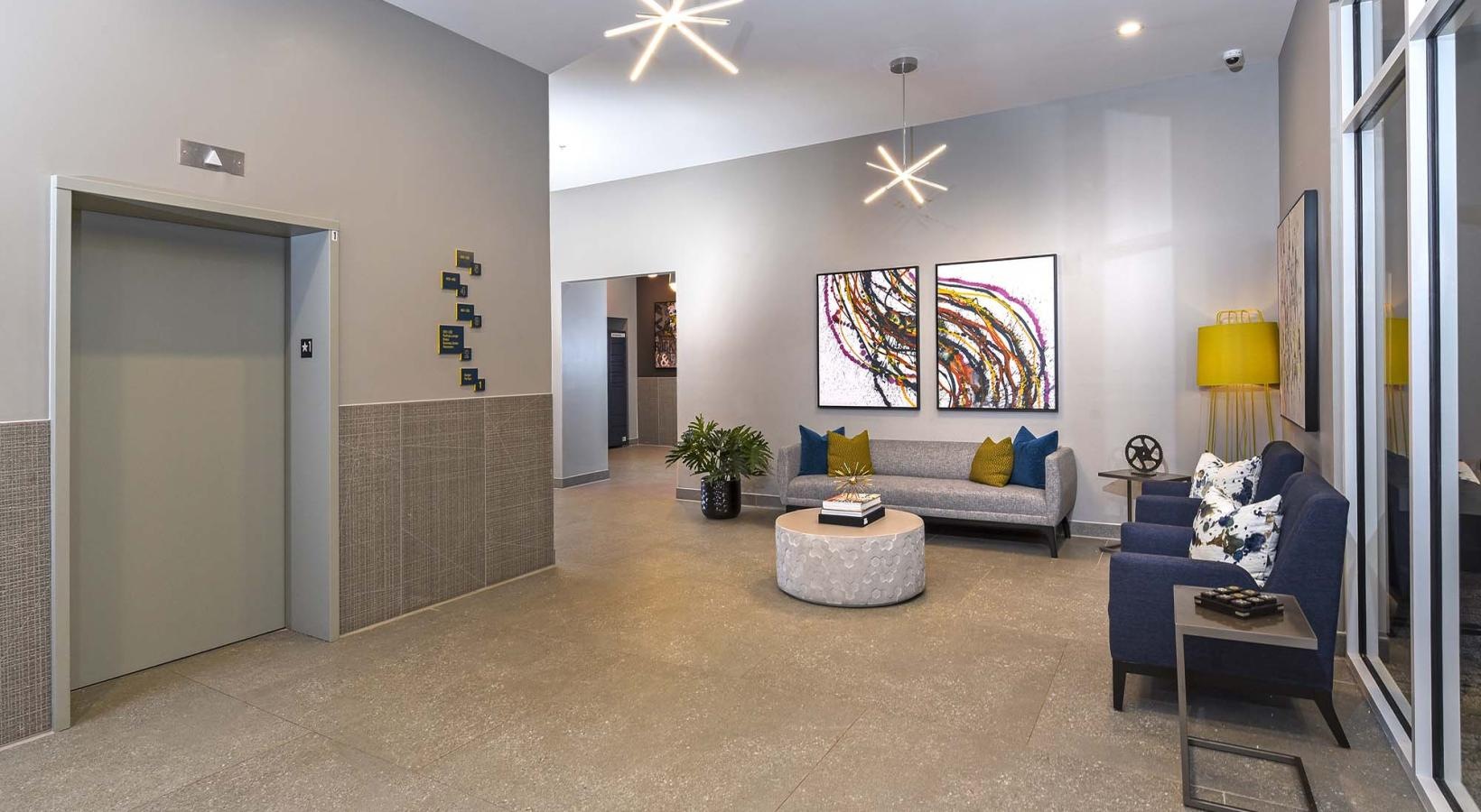 State-of-the-art amenities a clubroom with an elevator, couches and tables