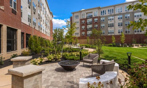 a courtyard with tables and chairs and a building in the background