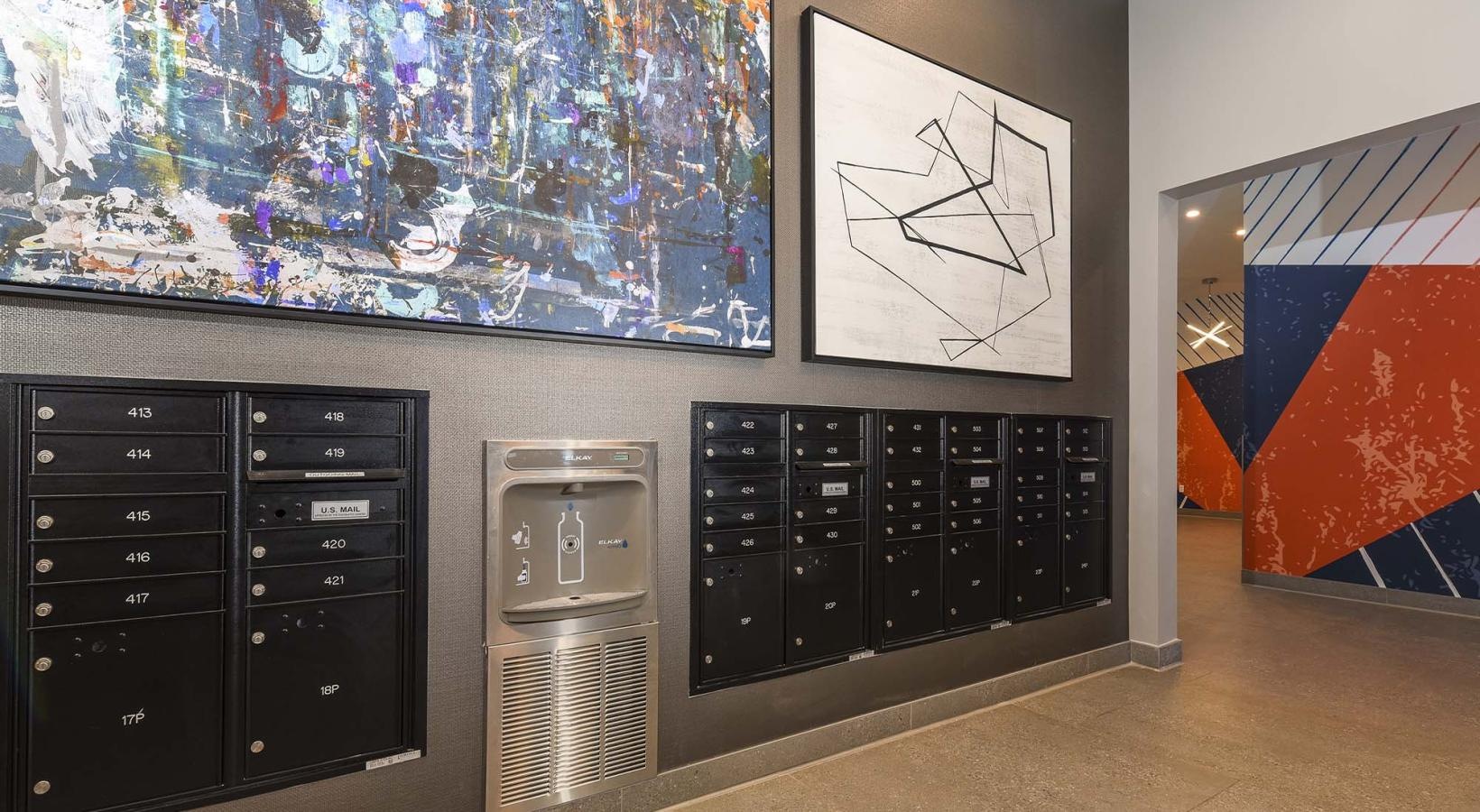 Quick access to state-of-the-art amenities a mail center with black mail boxes and wall art